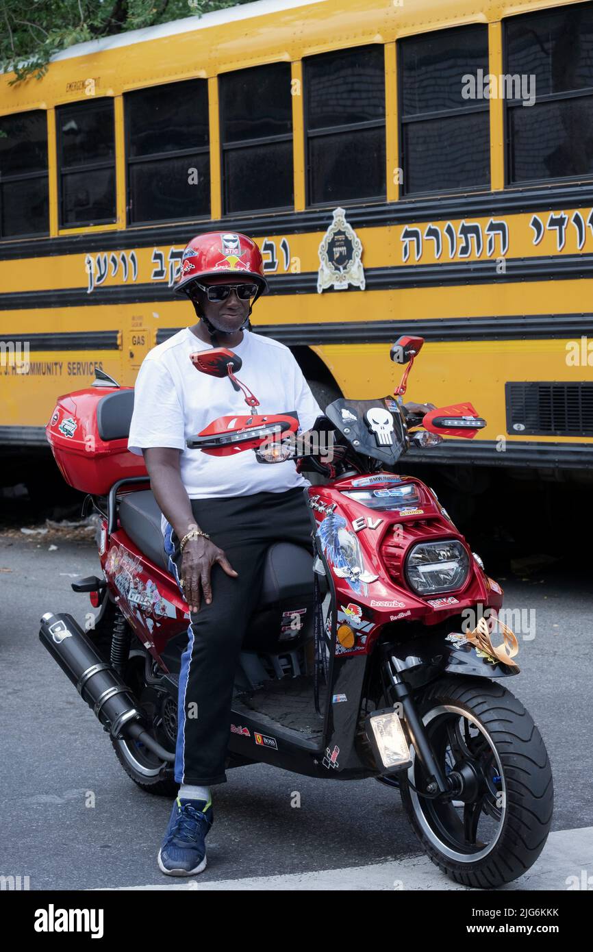 Ein Mann mittleren Alters auf einem Motorrad von Marshal 150cc hält für ein Licht in Williamsburg, Brooklyn, einem ultraorthodoxen Viertel in Brooklyn. Stockfoto