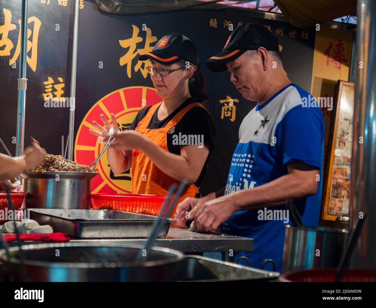 Taipeh, Taiwan - 2016. Oktober: Eine Gruppe glücklicher Taiwanesen bereitet auf einem typischen lokalen Nachtbasar in Taiwan mit vielen lokalen Produkten, Tajwan, Essen zu Stockfoto