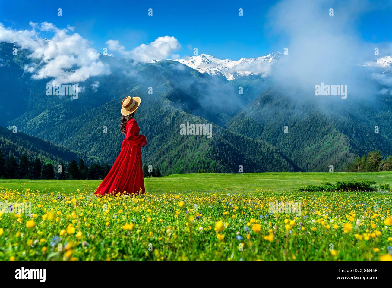 Touristen genießen Blick auf grüne Weide und Blumen in der Nähe von Schneeberg in Georgien. Stockfoto