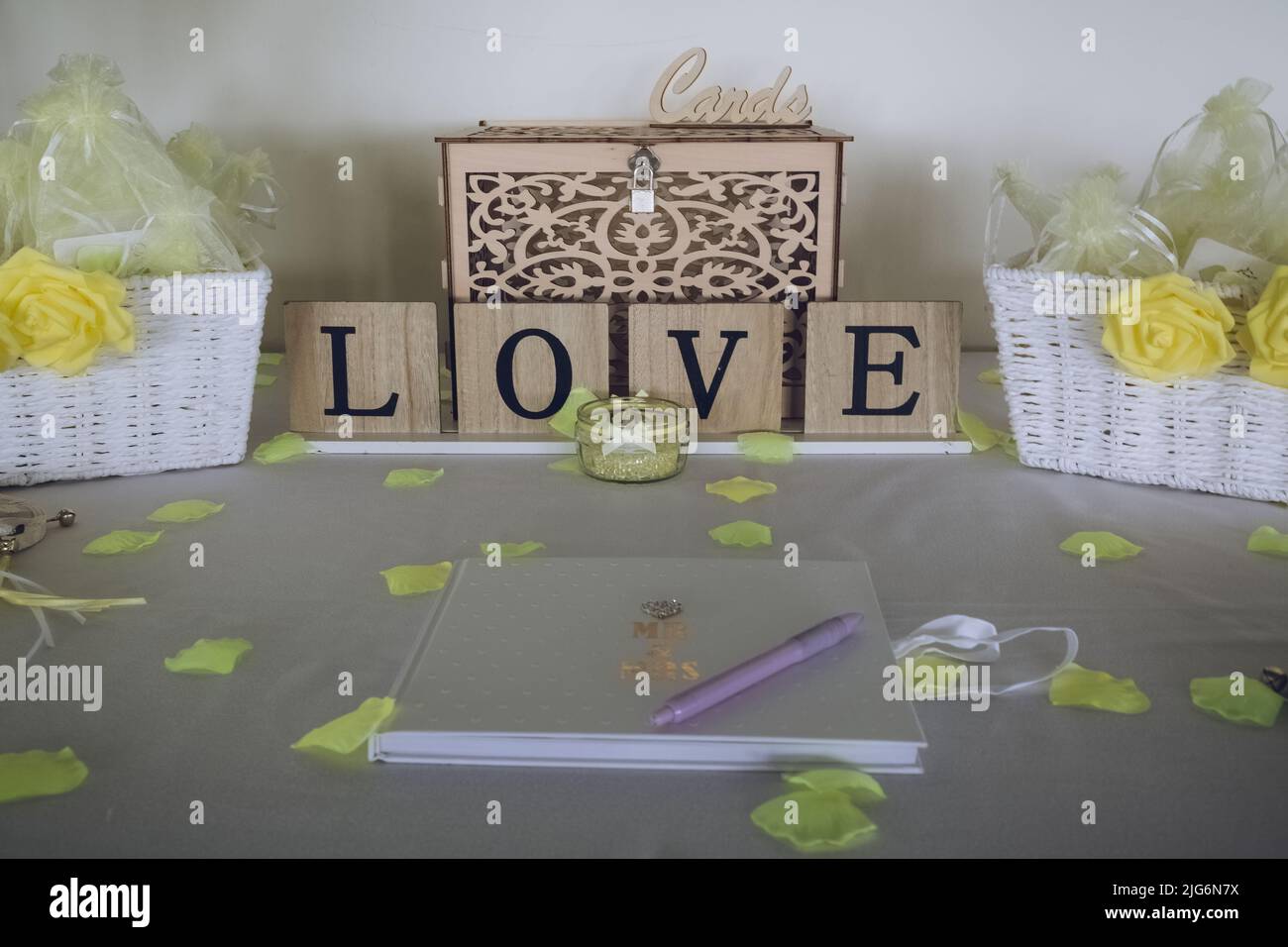 Ein Gästebuch für eine Hochzeit, das auf einem Tisch bei einem Hochzeitsempfang mit einem Schild mit der Aufschrift „Liebe“ ausgelegt ist Stockfoto