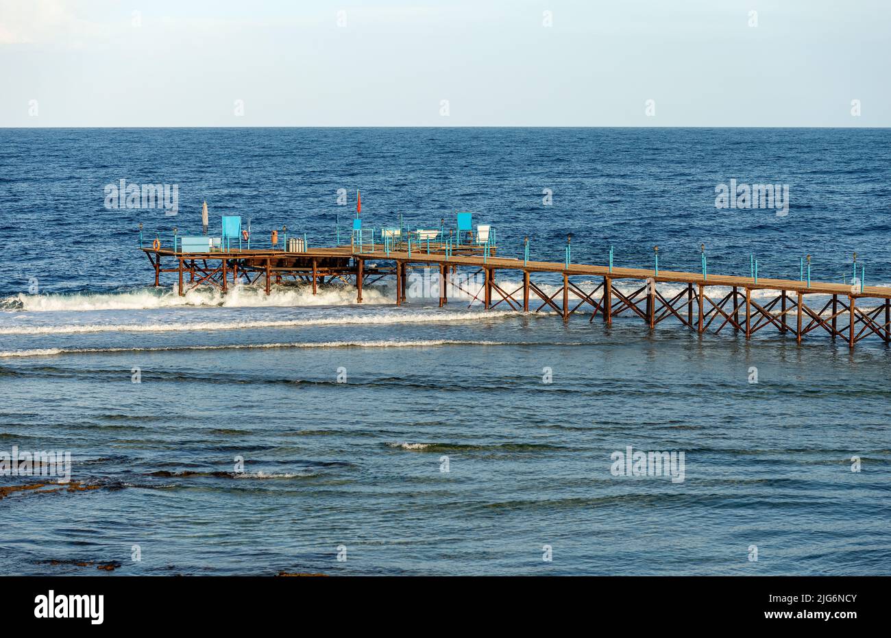Meereslandschaft des Roten Meeres bei Marsa Alam, Ägypten, Afrika. Hölzerner Pier über dem Korallenriff, der zum Tauchen, Schnorcheln und Schwimmen mit der roten Flagge verwendet wird. Stockfoto