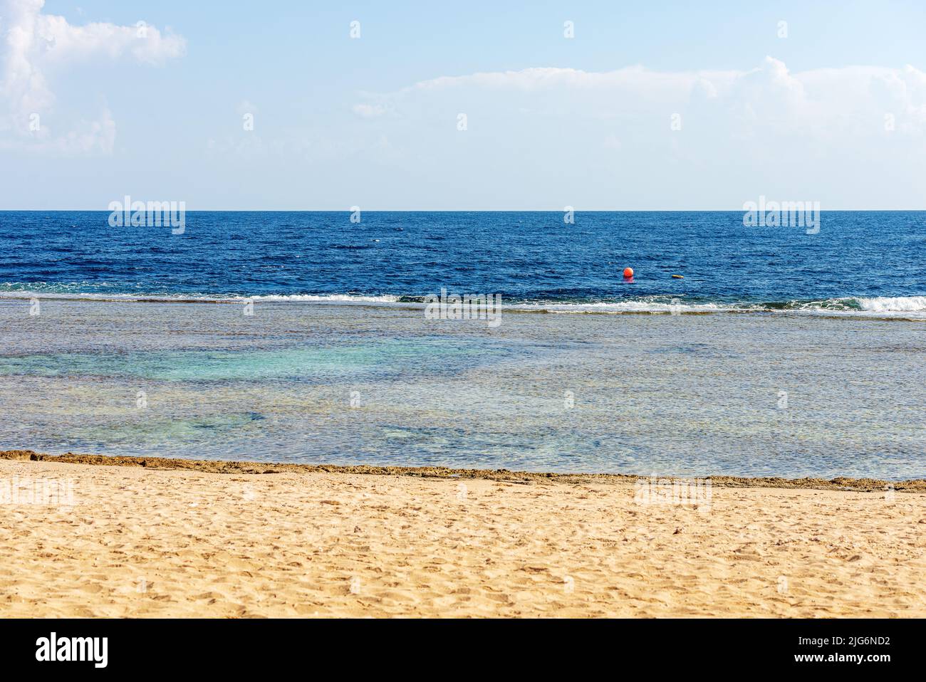 Seascape und schöner Sandstrand an der Küste des Roten Meeres mit Wellen brechen auf dem Korallenriff, in der Nähe von Marsa Alam, Ägypten, Afrika. Stockfoto