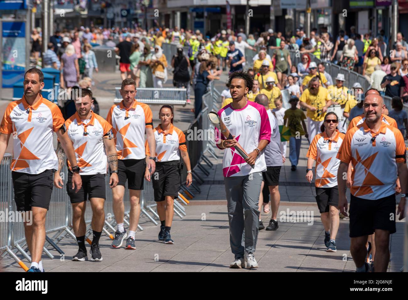 High Street, Southend on Sea, Essex, Großbritannien. 8. Juli 2022. Der Baton Relay der Queen hat die neue Stadt Southend on Sea auf seiner Reise nach Birmingham für die Commonwealth Games erreicht und wurde von ausgewählten Batonbearern von einem Ende der High Street zum anderen getragen. Sam Bennett, Jugendathlet mit Goldmedaille, nahm die erste Etappe an der Spitze der Prozession die High Street hinunter Stockfoto