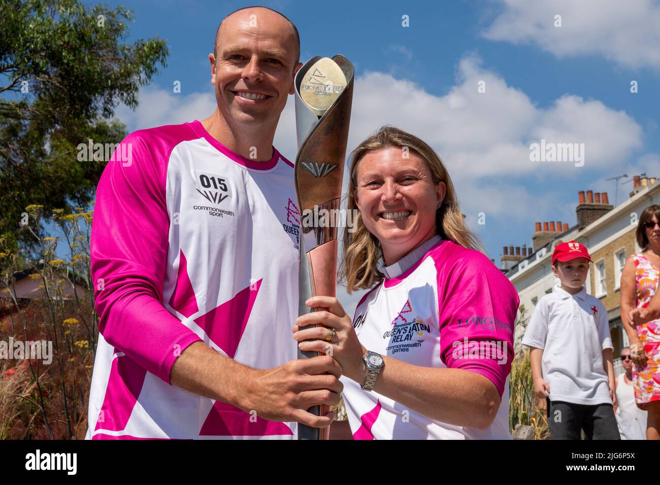 High Street, Southend on Sea, Essex, Großbritannien. 8. Juli 2022. Der Baton Relay der Queen hat die neue Stadt Southend on Sea auf seiner Reise nach Birmingham für die Commonwealth Games erreicht und wurde von ausgewählten Batonbearern von einem Ende der High Street zum anderen getragen. Die zweite und dritte Person, die den Stab auf diesem Bein trug, war Lisa Whymark, die die Übergabe an den Olympiateilnehmer Dean Macey sah. Lisa Whymark von Brentwood leitet die gemeinnützige Organisation Hutton Daily Bread Cafe. Stockfoto