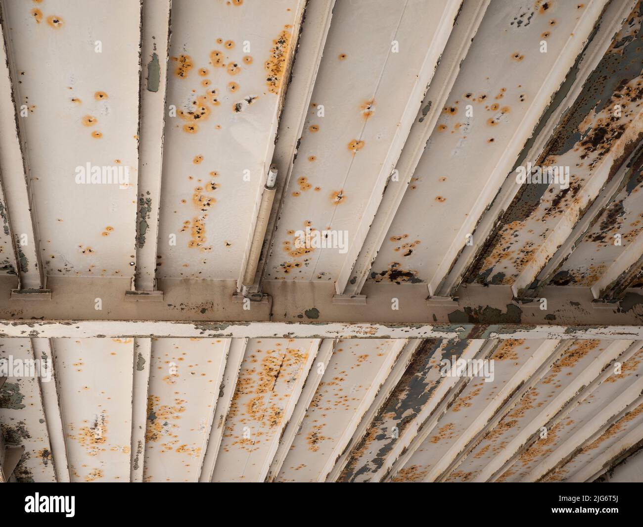 Rostige Unterseite einer Stahlbrücke mit abblätternder Farbe Stockfoto