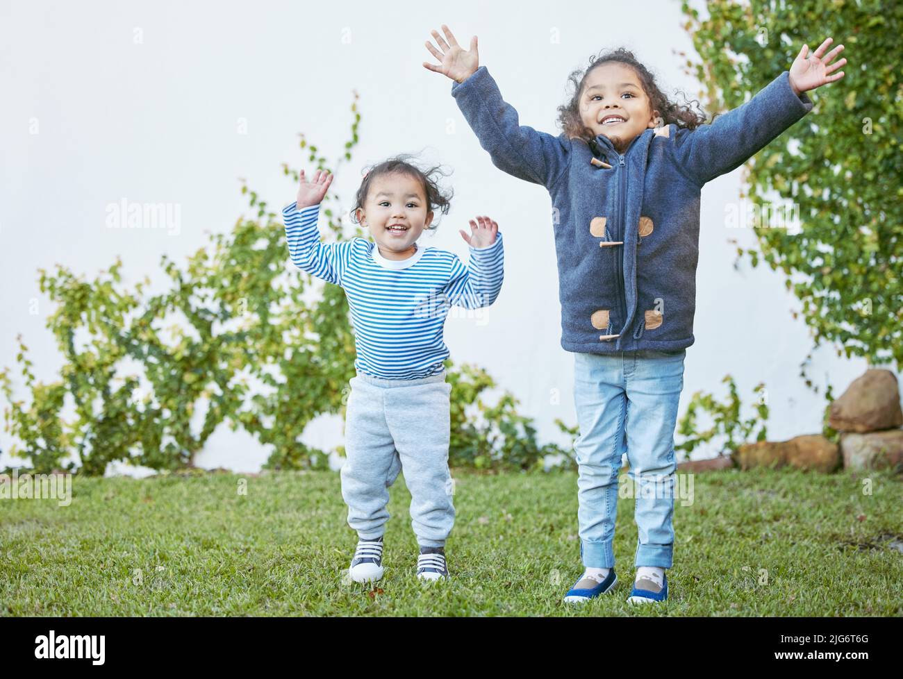 Waren so glücklich, den Tag draußen zu verbringen. Aufnahme von zwei kleinen Mädchen, die draußen zusammen spielen. Stockfoto