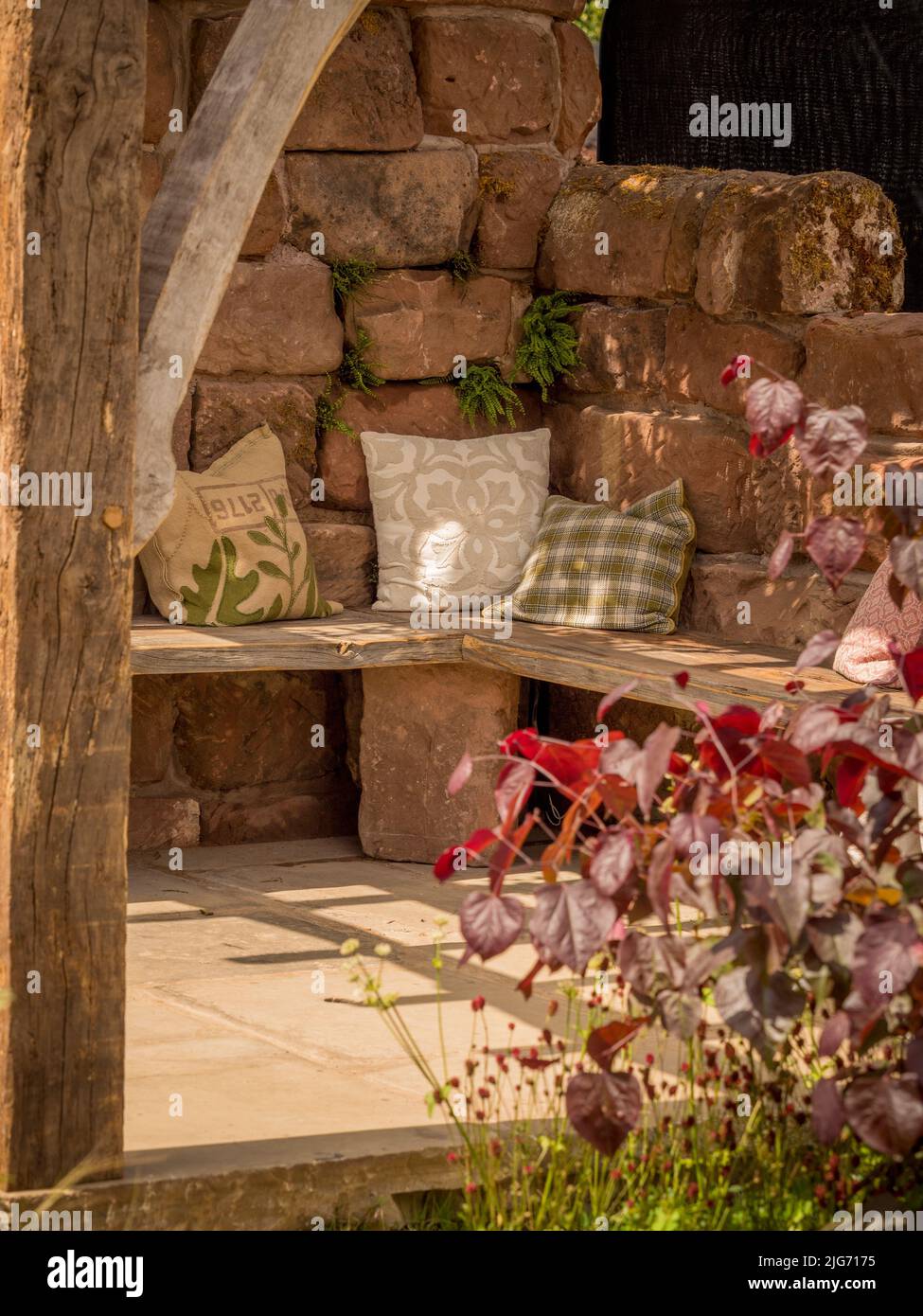 Holzgartensitz mit Streuspitzen, Teil eines Showgartens in der Hampton Court Palace Gartenschau in London. Stockfoto