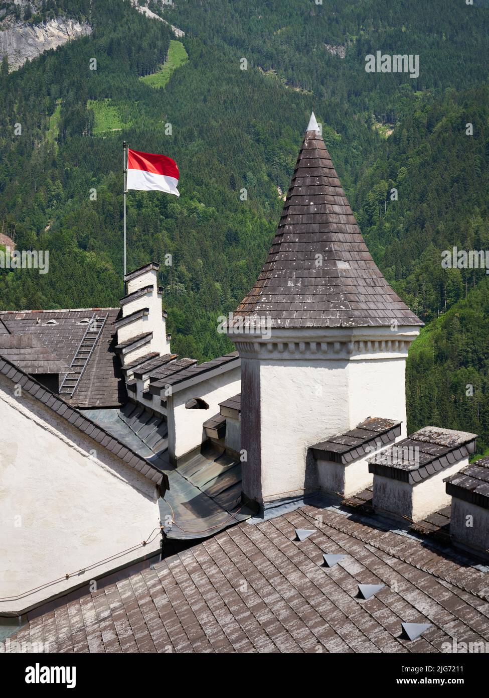 Schlossdächer, Turm und Flagge auf Schloss Hohenwerfen, Salzburg, Österreich Stockfoto