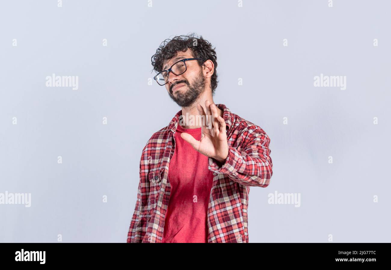 Person mit der Hand in der Front, die etwas ablehnt. Negativer Mann, der mit einer Hand ablehnt, gutaussehender Mann mit Ablehnungsausdruck Stockfoto