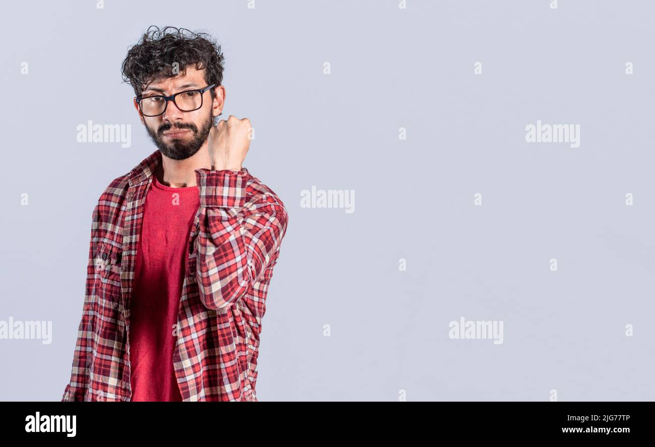 Mann mit aggressivem Gesichtsausdruck, der seine Faust vor die Kamera zeigt, ernster Mann mit seiner Faust vor die Kamera Stockfoto