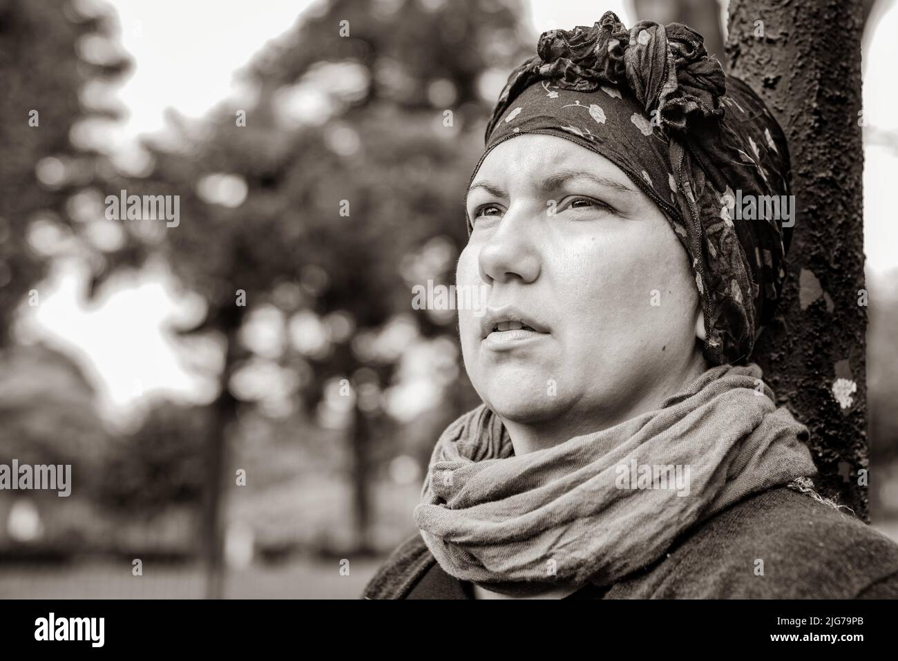 Frau mit Krebs im Kopftuch im Freien. Schwarz-Weiß-Aufnahmen Stockfoto