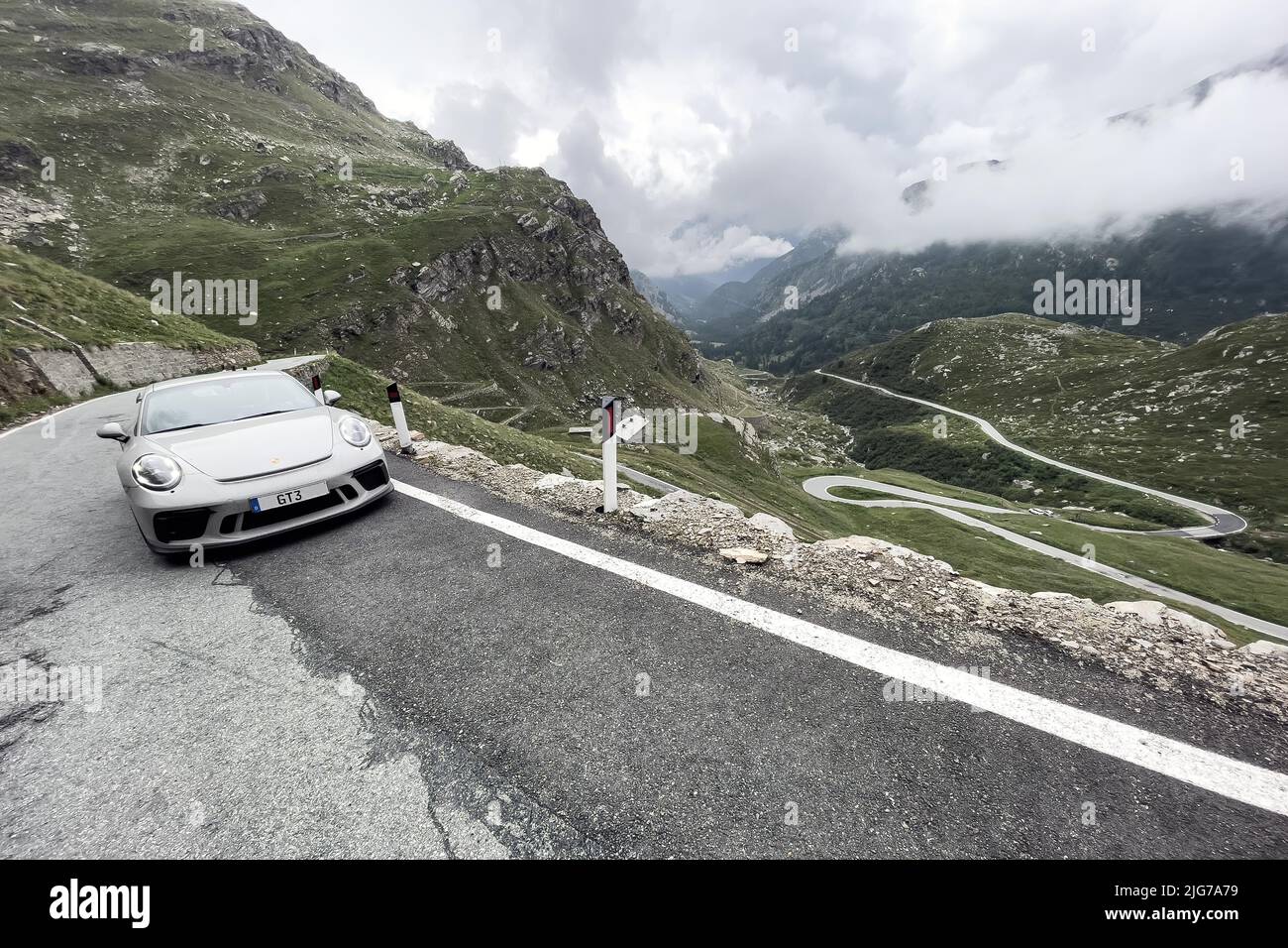 Supersportwagen Porsche 911 GT3 auf Passstraße in den Alpen nach Colle del Nivolet, rechter Hintergrund Serpentinenkurven, Col du Nivolet, Graian Stockfoto