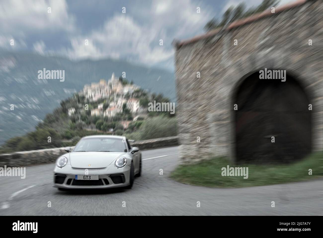 Dynamisches Foto mit Geschwindigkeitseffekt des Supersportwagens Porsche GT3 in enger Kurve der historischen Strecke der Rallye Monte Carlo 1965, im Hintergrund La Stockfoto