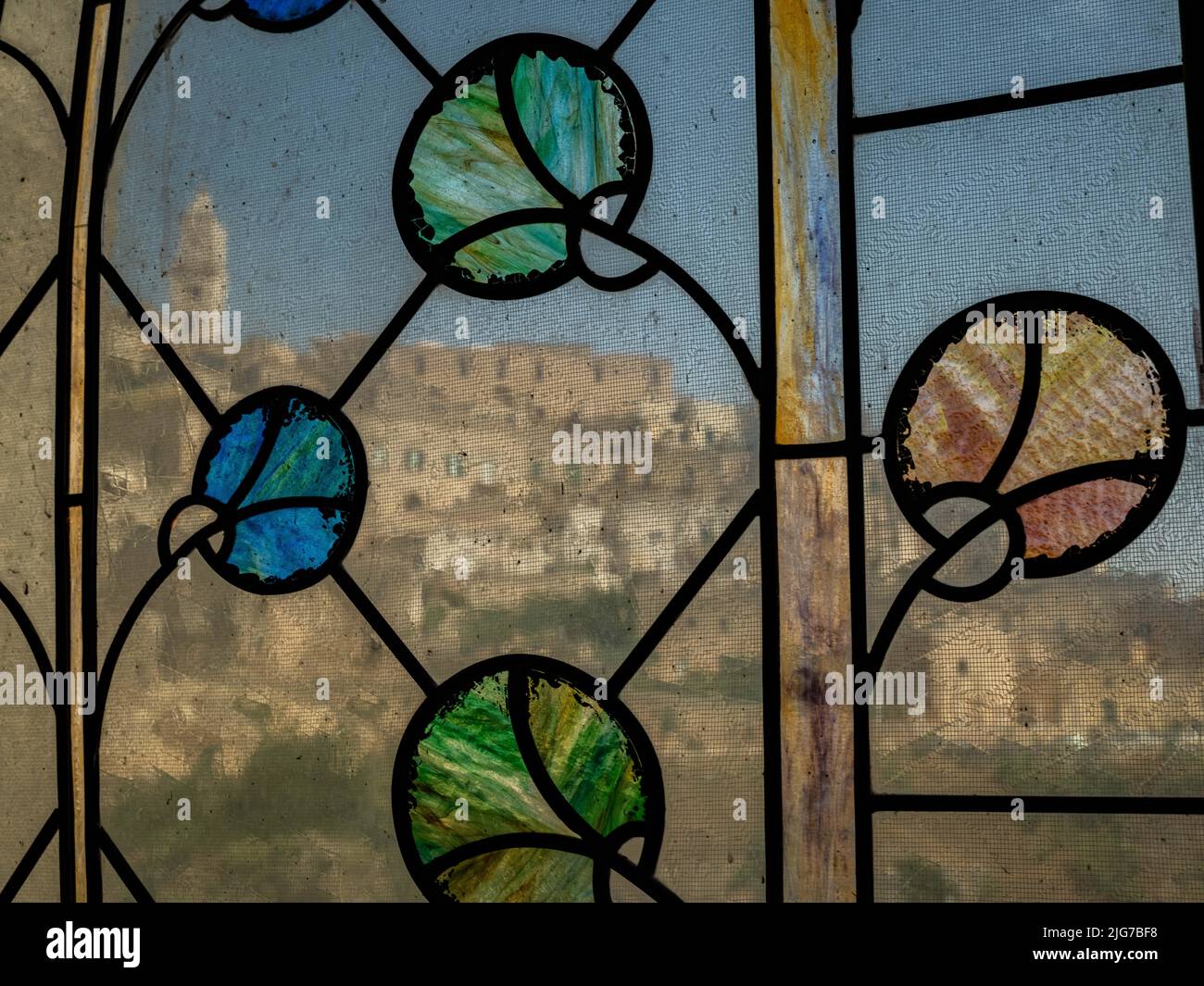 Panoramablick auf das alte Sassi-Viertel von Matera durch ein Buntglasfenster in einer Kirche im Tal Stockfoto