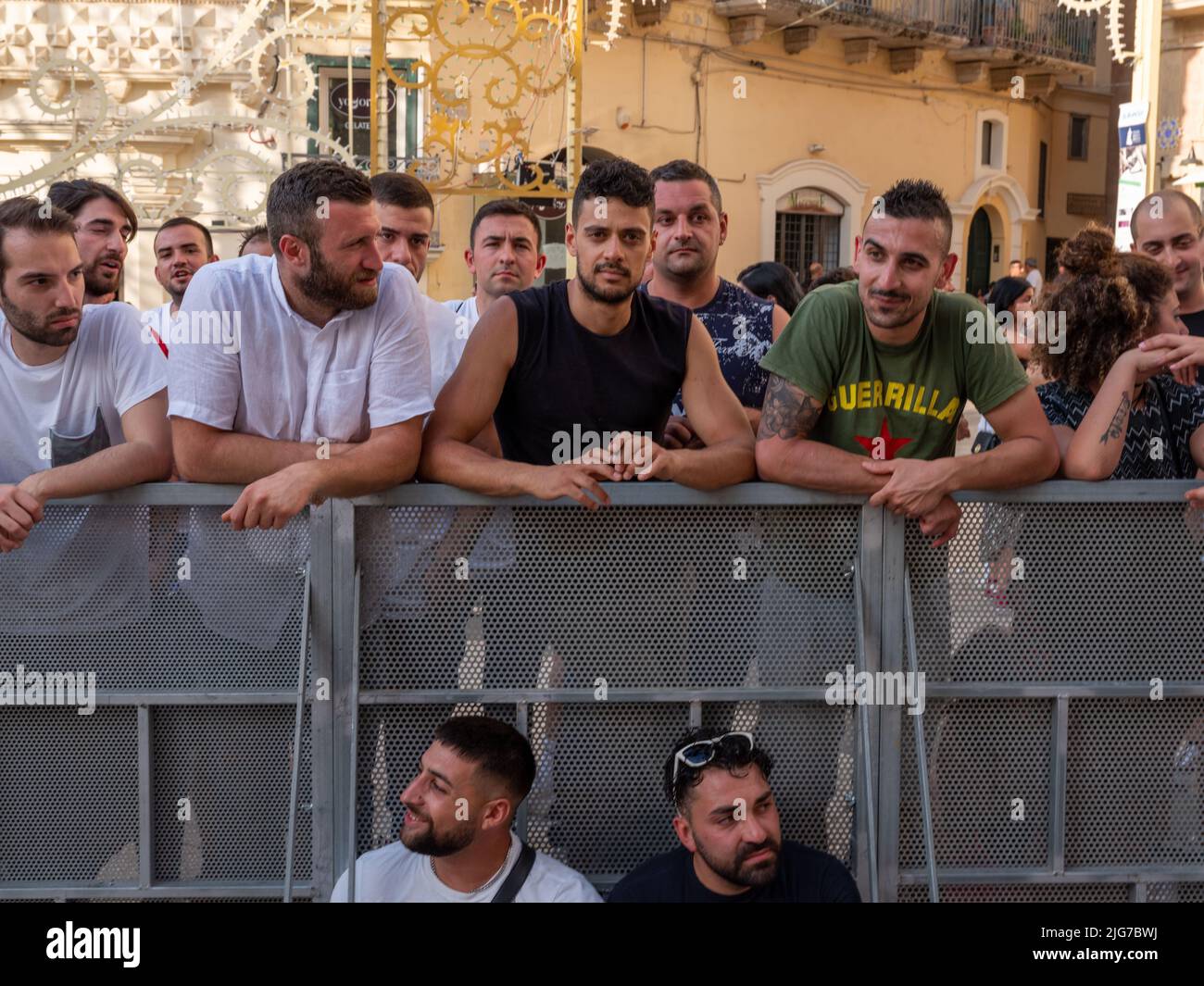 Menschenmengen und junge Männer erwarten die Prozession der braunen Madonna in Mdera, Italien, um den Wagen mit der heiligen Statue anzugreifen Stockfoto