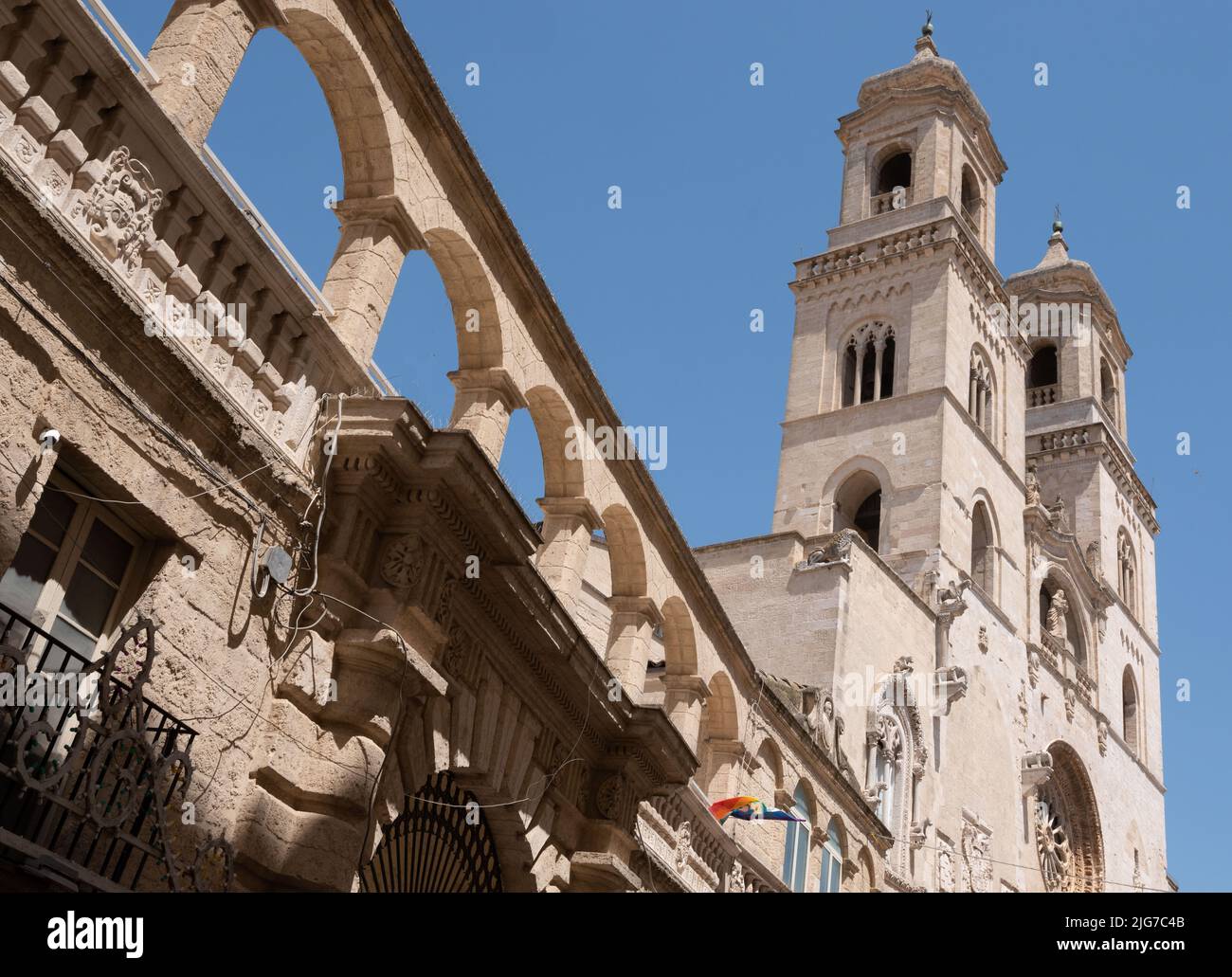 Die barocke Kathedrale der apulischen Stadt Altamura in Italien mit ihren zwei Glockentürmen, Rosenfenstern und Zierbögen an der Seite. Stockfoto