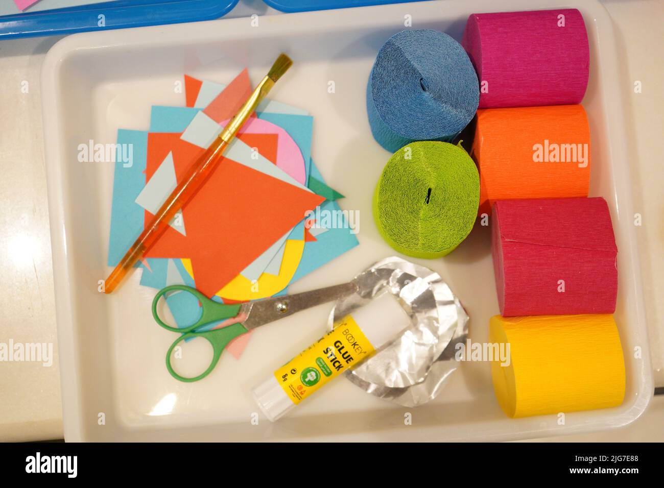 Kids Basteln Kit auf einem weißen versuchen. Tissue Papier, Schere, Kleber, Folie, ein Stück Papier, und ein Pinsel Stockfoto