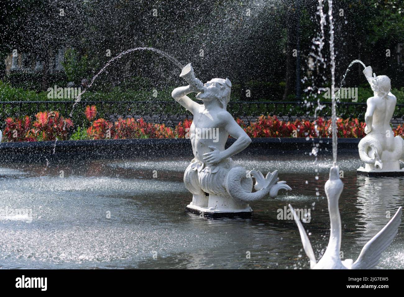 Wasser schießt aus einer Schale, die von einer Triton-Statue im Forsyth Park Fountain im historischen Savannah, Georgia, geblasen wird. Stockfoto