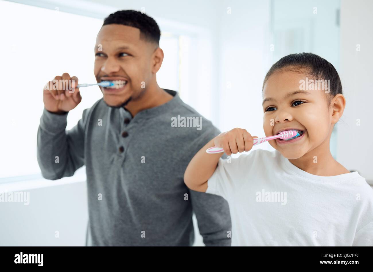 Was für eine Vaterfigur. Aufnahme eines entzückenden kleinen Mädchens und ihres Vaters, der zu Hause ihre Zähne putzt. Stockfoto