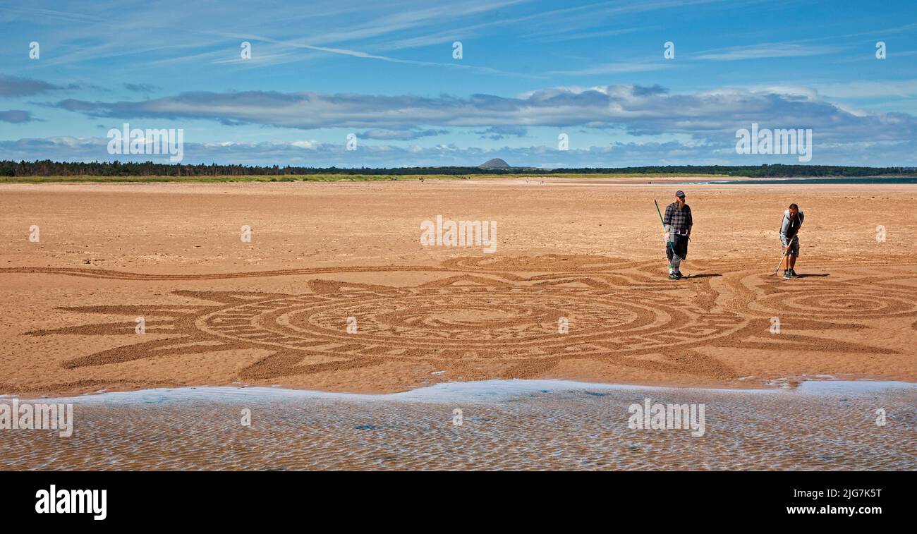 Belhaven Bay, East Lothian, Schottland, Großbritannien. 8.. Juli 2022. Sand Drawing beim European Land Art Festival und bei den Stone Stacking Championships, die von James Craig Page durchgeführt werden, war dies ein Tag der psychischen Gesundheit und des Wohlbefindens, an dem Künstler mitwirkten: John Foreman aus Wales, Pedro Duran aus Spanien, Arron Tierney aus Schottland, Steve Winter aus Südafrika. Sonnenschein und starker Wind bei 38 km/h und mögliche Böen von 66 km/h machten das Leben etwas schwierig. Das einwöchige Festival endet an diesem Wochenende. Quelle: Arch White/alamy Live News Stockfoto