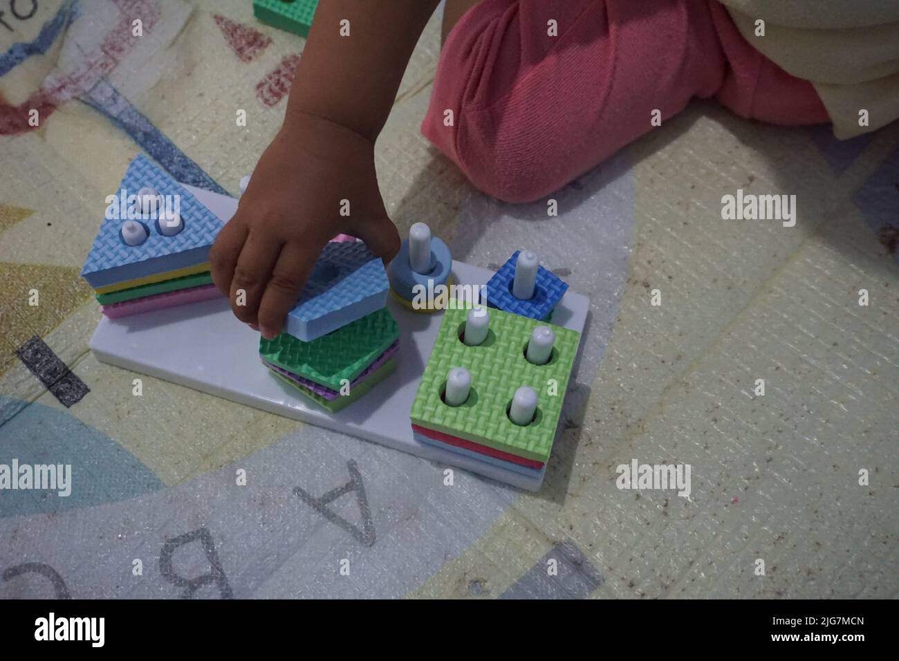 Kinderhand, spielt mit montessory Spielzeug. Geometrie Puzzle. Bildung für Kinder, die natürliche Interessen und Aktivitäten zu entwickeln sucht. Stockfoto