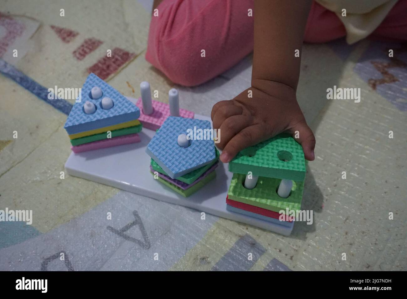 Kinderhand, spielt mit montessory Spielzeug. Geometrie Puzzle. Bildung für Kinder, die natürliche Interessen und Aktivitäten zu entwickeln sucht. Stockfoto