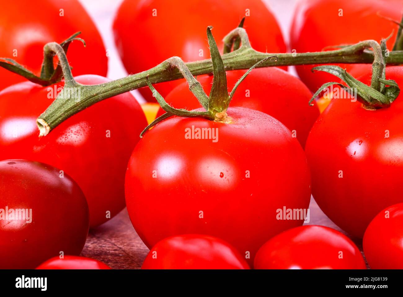 Frische reife Weintomaten, umgeben von Pflaumen- und Kirschtomaten Stockfoto