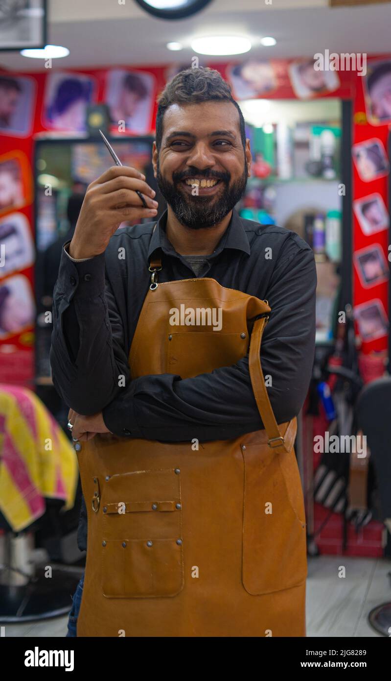 Glücklicher Barbier arabischer Mann Porträt mit Schere Stockfoto
