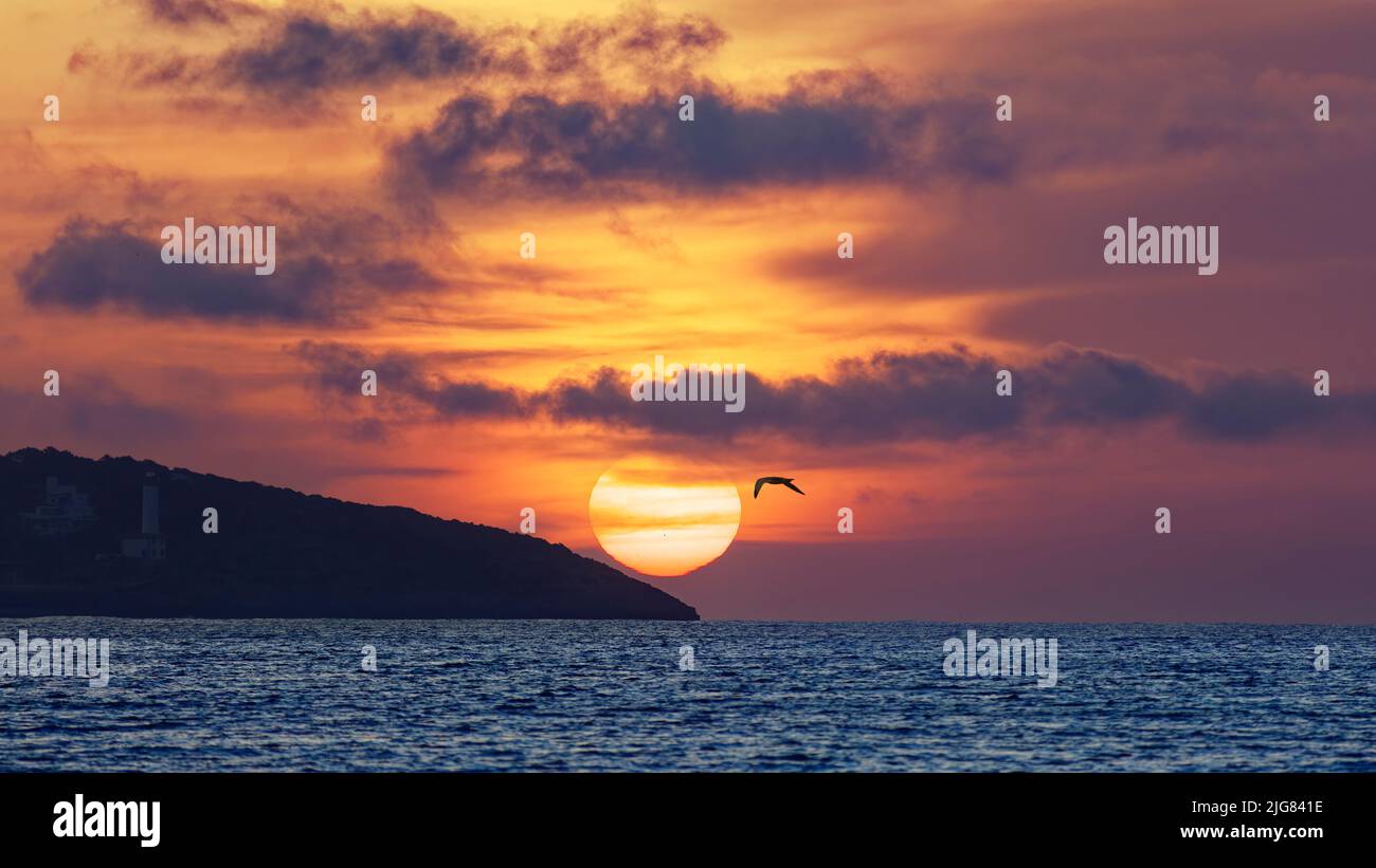 Sonnenaufgang mit großer Sonne in Ibiza-Stadt, Playa d'en Bossa Stockfoto