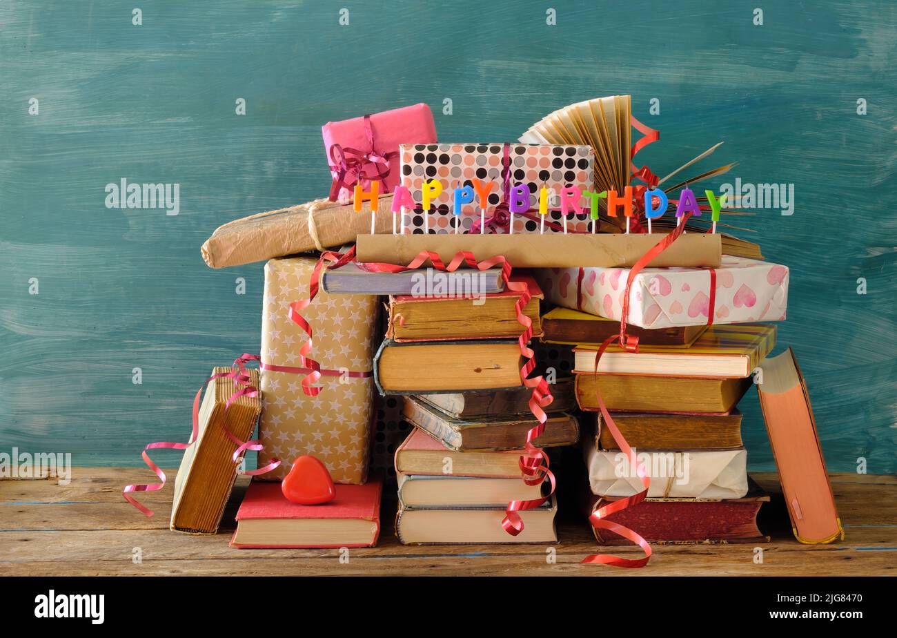 Bücher als Geburtstagsgeschenk, Reihe von Büchern, Geburtstagskerzen, Geschenk verpackt Bücher, Literatur, Lesen und Bildungskonzept. Stockfoto