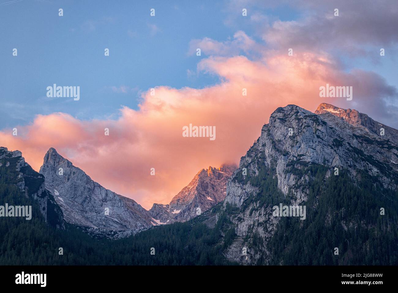 Blick auf die Gipfel des Hochkalter-Massivs im Morgengrauen, mit Alpenglühen und rot glühenden Wolken, Ramsau, Bayern, Deutschland, Stockfoto