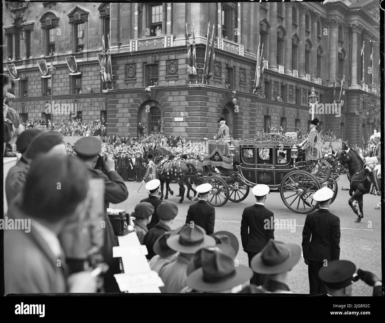 Krönung von Königin Elizabeth II., Parliament Square, City of Westminster, Greater London Authority, 02-06-1953. Ein Blick auf den Parliament Square, der Menschenmassen zeigt, die beobachten, wie der Bus, der Prinzessin Margaret und die Königin Mutter trägt, während der Krönungsprozession von Königin Elizabeth II. Vorbeifährt Stockfoto