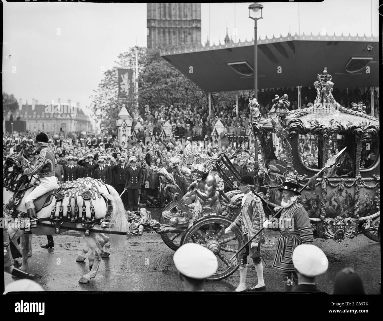 Krönung von Königin Elizabeth II., Parliament Square, City of Westminster, Greater London Authority, 02-06-1953. Menschenmassen auf dem Parliament Square beobachten, wie der Gold State Coach, der Königin Elizabeth II. Trägt, während der Krönungsprozession vorbeifährt. Stockfoto
