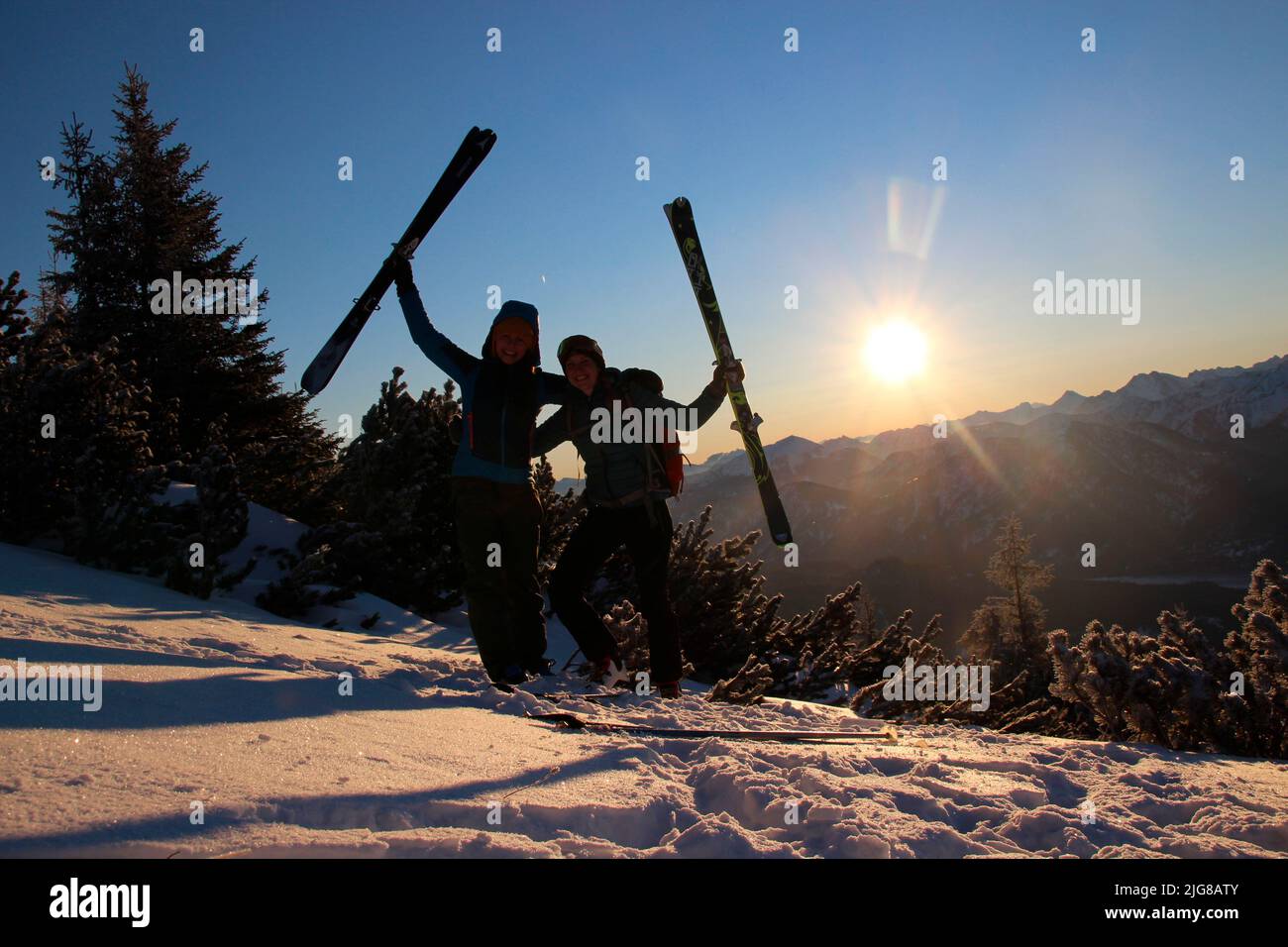 Zwei junge Frauen auf Winterwanderung, Skitour nach Simetsberg. Deutschland, Bayern, Walchensee, Einsiedl, Gipfelkreuz um 1840m Uhr Stockfoto