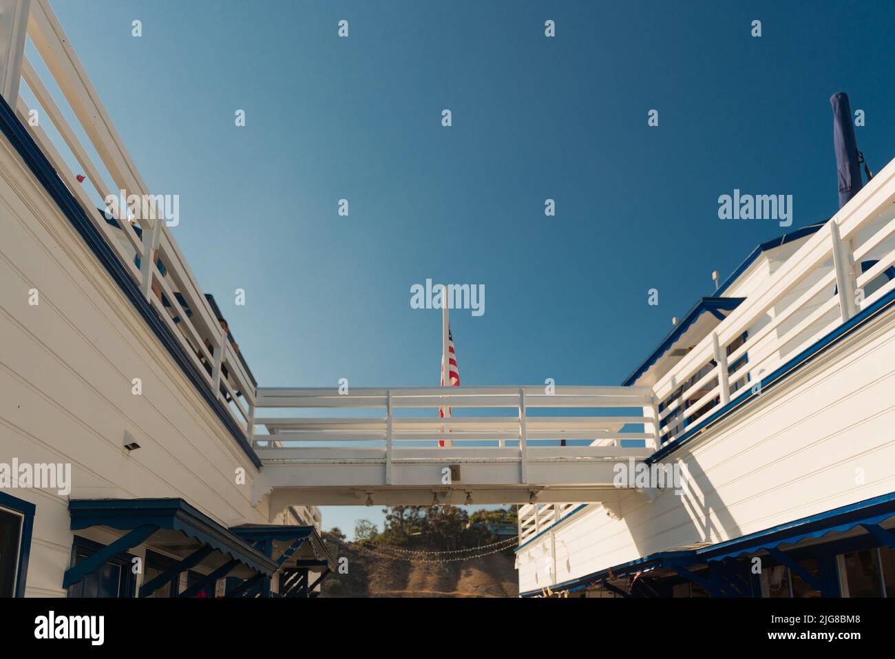 Eine Aufnahme eines Skywalk zwischen zwei Gebäuden mit amerikanischer Flagge am Malibu Pier Stockfoto