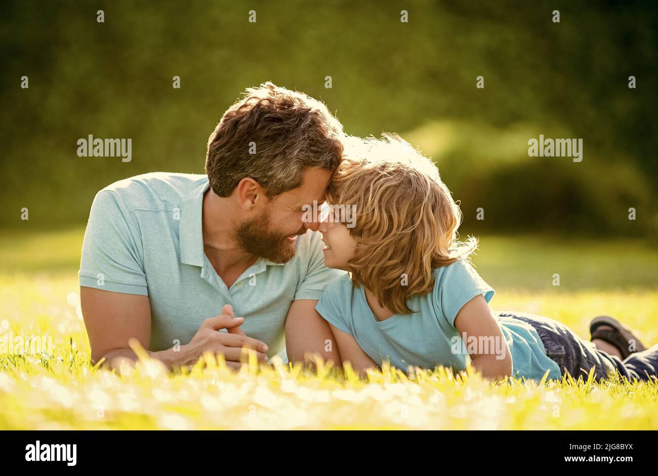 Eltern entspannen mit kleinen Jungen auf Gras. Papa mit Kind am Sommertag. Elternschaft und Vaterschaft Stockfoto