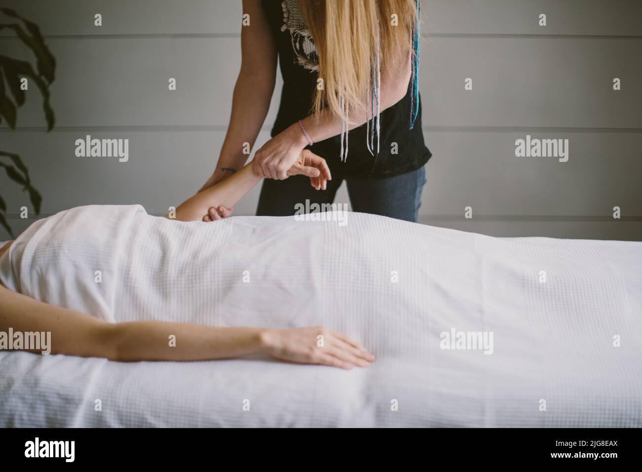 Eine kaukasische Frau, die die Arme eines Klienten massiert Stockfoto