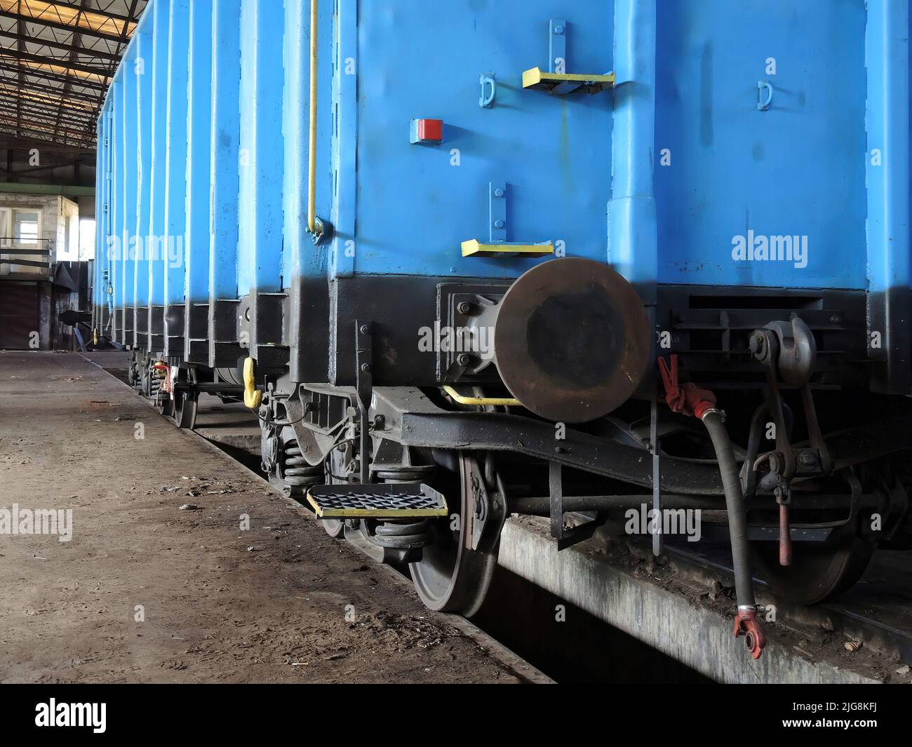 Blauer Wagen in einer alten Werkstatt von Waggons und Lokomotiven. Ort der Reparatur und Renovierung für Züge. Stockfoto