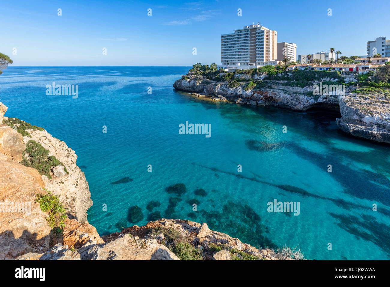 Spanien, Balearen, Mallorca, Bezirk Manacor, Calas de Mallorca. Cala Antena und die weißen Resorts mit Blick auf die Bucht Stockfoto