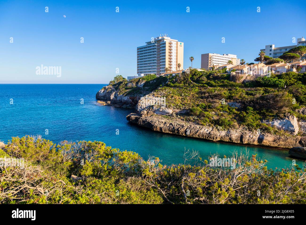 Spanien, Balearen, Mallorca, Bezirk Manacor, Calas de Mallorca. Cala Antena und die weißen Resorts mit Blick auf die Bucht Stockfoto