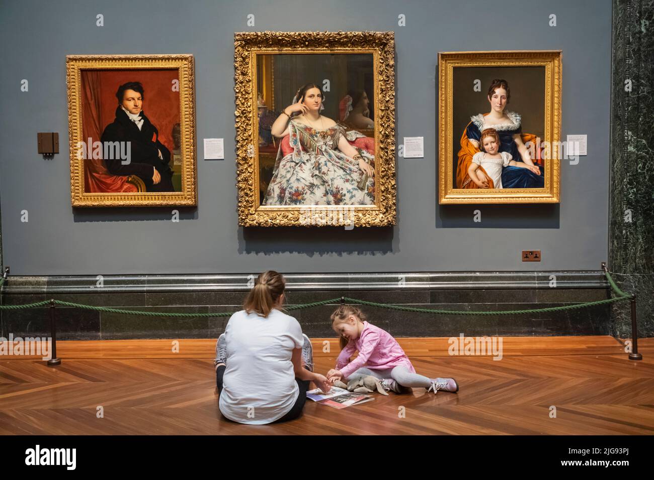 England, London, die Nationalgalerie, Mutter und Kind sitzen vor Kunstwerk Stockfoto