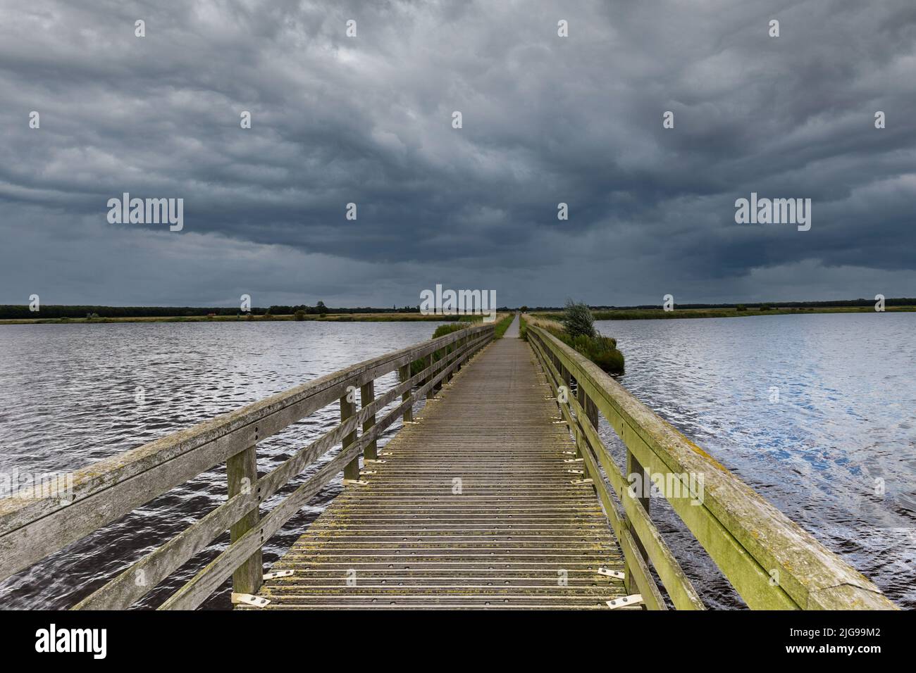 Landschaftsschutzgebiet 't Roegwold in der Nähe der Stadt Schildwolde in der niederländischen Provinz Groningen mit Club Weg durch das Wasser gegen einen backgr Stockfoto