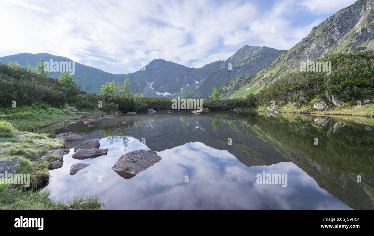 Noch alpiner tarn spiegelt die umliegenden Berge und Umwelt, Slowakei, Europa Stockfoto