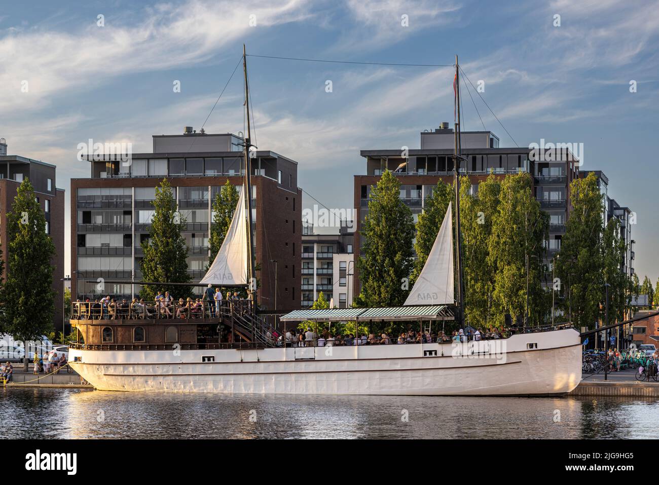 Menschen treffen sich im Hafengebiet, um einen warmen Sommerabend zu verbringen Stockfoto