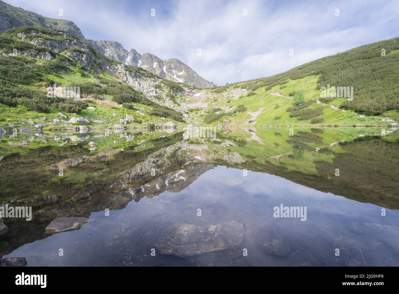 Immer noch kristallklares alpines tarn spiegelt seine Umgebung wie ein Spiegel, Slowakei, Europa Stockfoto