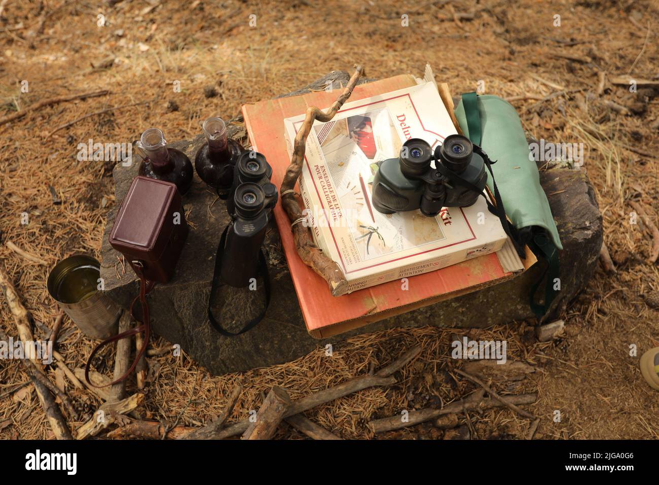 Spiel für Kinder. Magische Ausrüstung im Wald in den Bergen. Binokular, Bücher, Karten Stockfoto