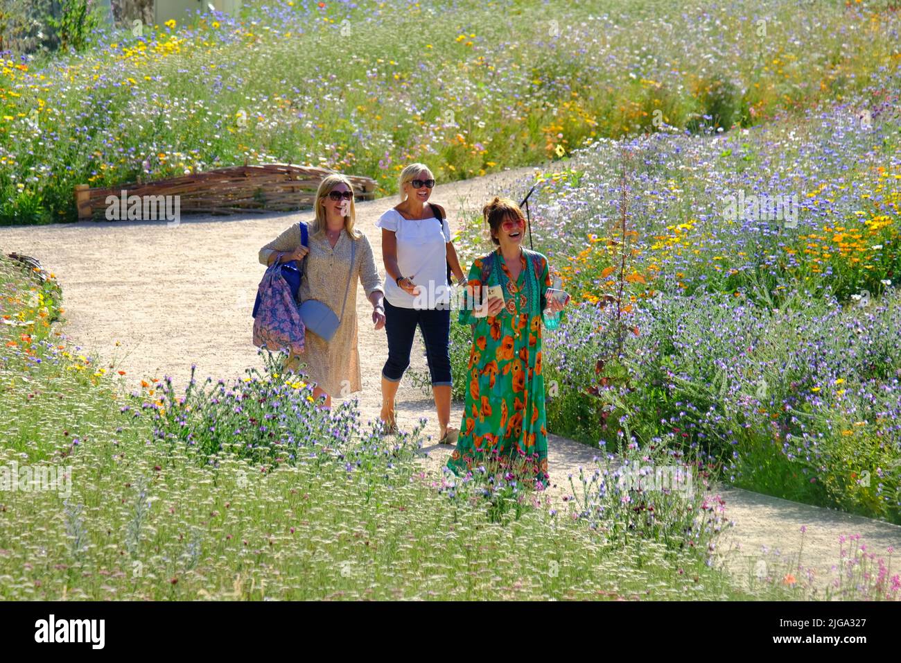 London, Großbritannien. 8.. Juli 2022. Die Besucher genießen die wunderschöne Blumenpracht „Superbloom“, da das kürzlich heiße und sonnige Wetter es den anfangs kämpfenden Pflanzen ermöglicht hat, im Graben des Tower of London zu gedeihen. Zur Feier des Platin-Jubiläums der Königin wurden über 20 Millionen Samen aus einer Vielzahl von blühenden Pflanzen gesät, um bestäubende Insekten zu fördern, wobei einige ausgewählt wurden, die von der Krone des Monarchen inspiriert wurden. Die Ausstellungen werden sich im Laufe der Monate entwickeln, wenn die Besucher erwarten können, im Sommer verschiedene Blumen zu sehen, die in Richtung Herbst gehen. Kredit: Elfte Stunde Fotografie/Alamy Live Neu Stockfoto