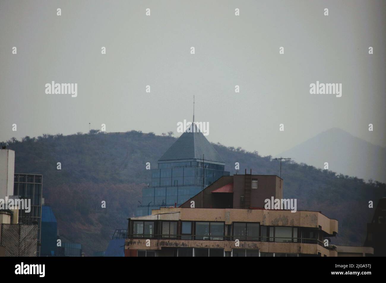 Blick auf ein Gebäude mit dem dahinter liegenden Hügel in Santiago, Chile Stockfoto