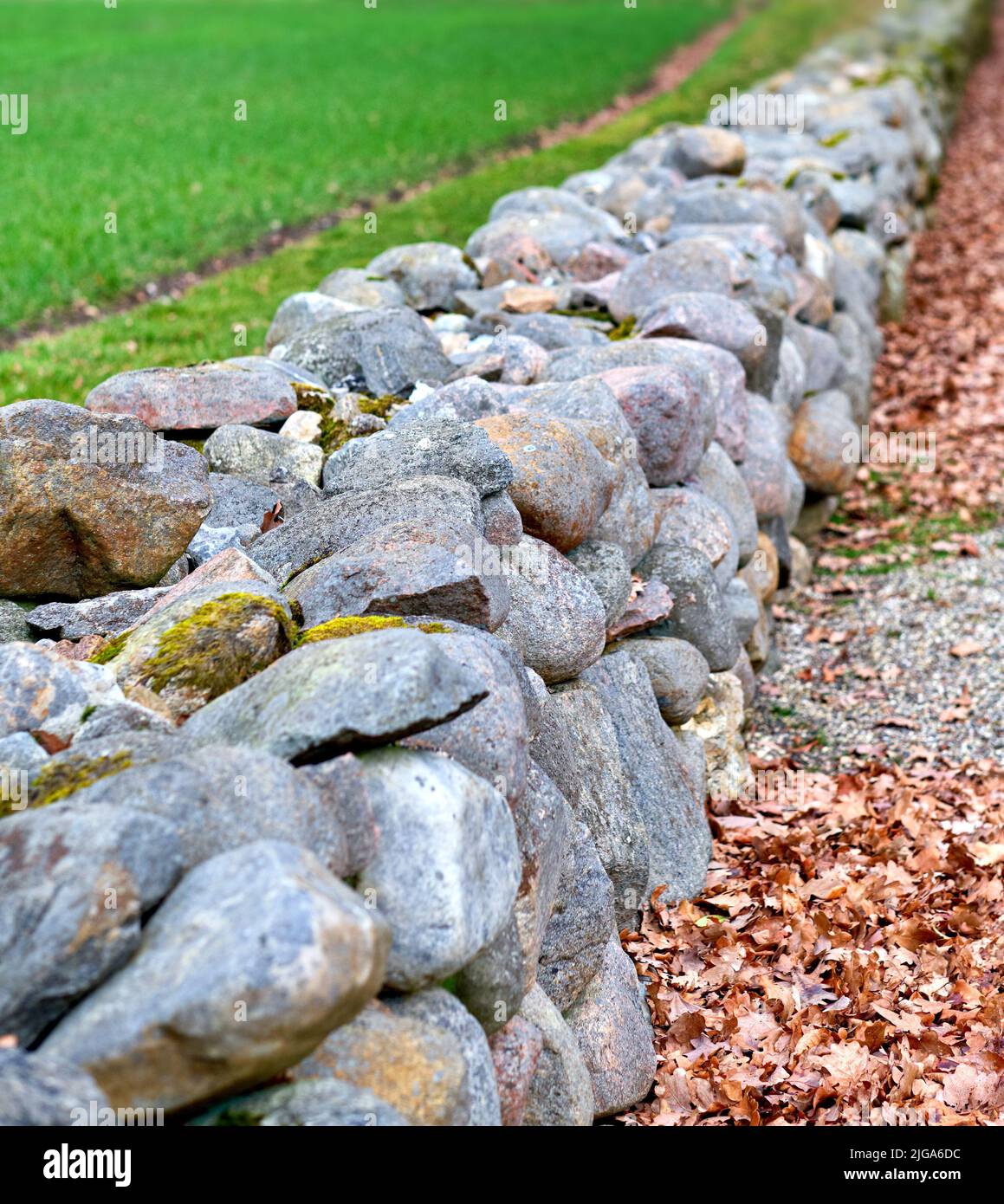 Nahaufnahme einer Steinmauer aus Felsbrocken und Felsen draußen. Hintergrund aus rustikalem, ländlichem Gebäude und Mauerwerk. Historisches Wohndesign oder Stockfoto