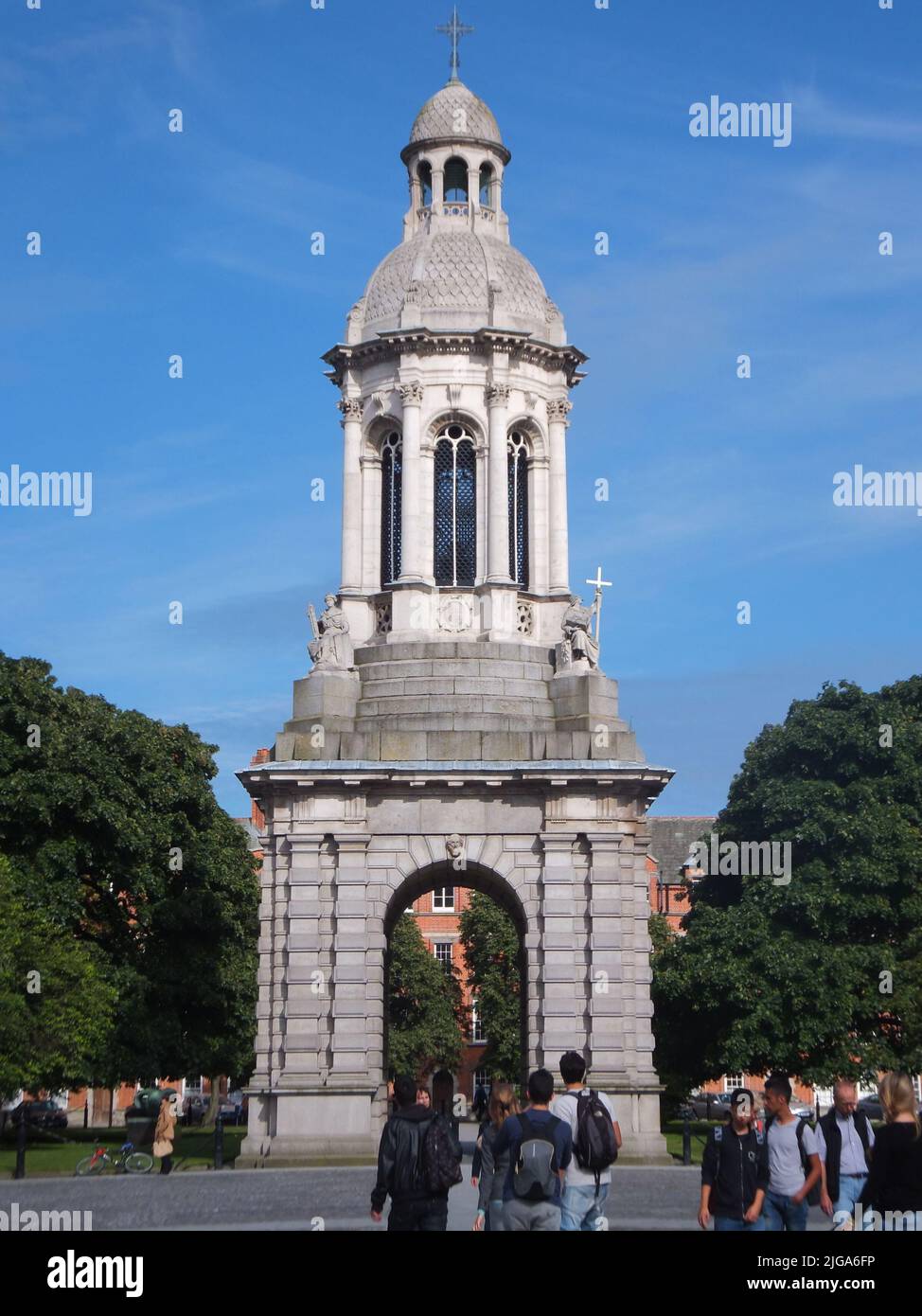 Studenten kommen am Campanile des Trinity College aus dem Jahr 1853 vorbei, das von Sir Charles Lanyon entworfen und von Thomas Kirk in Dublin, Irland, modelliert wurde. Stockfoto